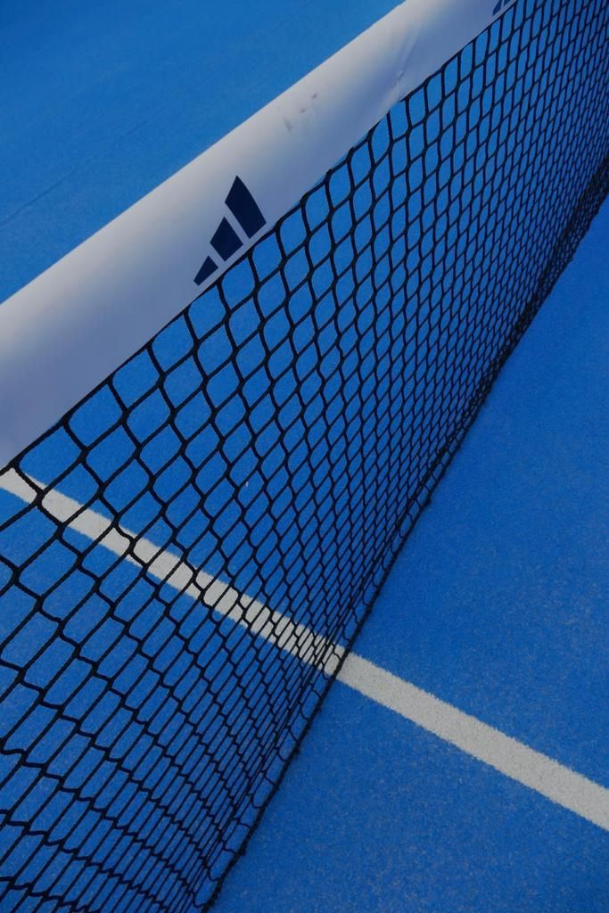 Rete da tennis su un campo blu con il logo Adidas.