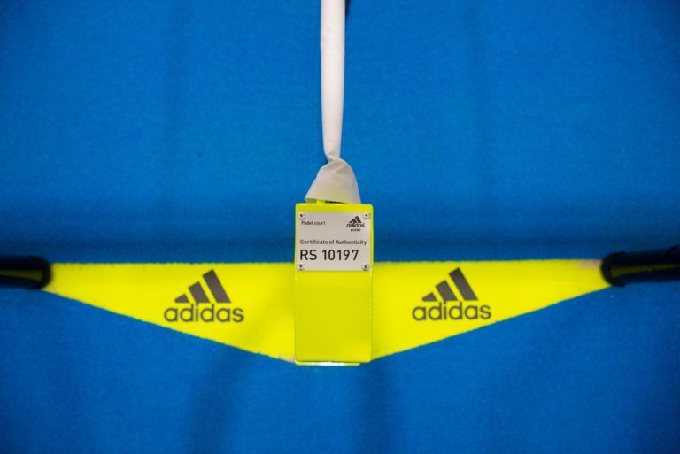 Etichetta di abbigliamento Adidas blu e gialla con la scritta