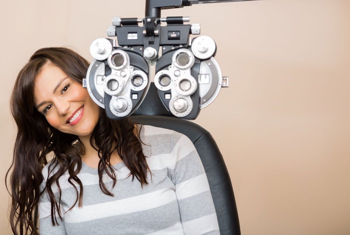 Woman having her eyes examined with a phoropter in an eye doctor's office.