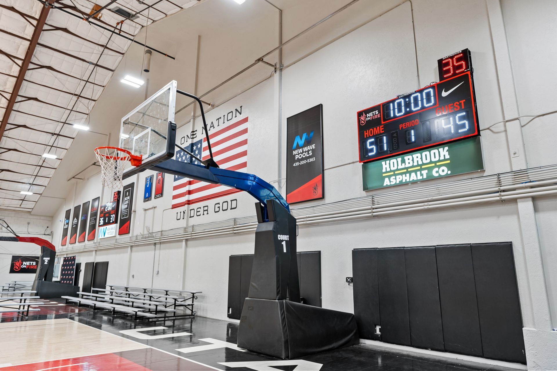 A basketball court with a basketball hoop and a scoreboard.