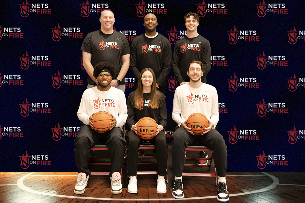 A group of people holding basketballs on a basketball court.