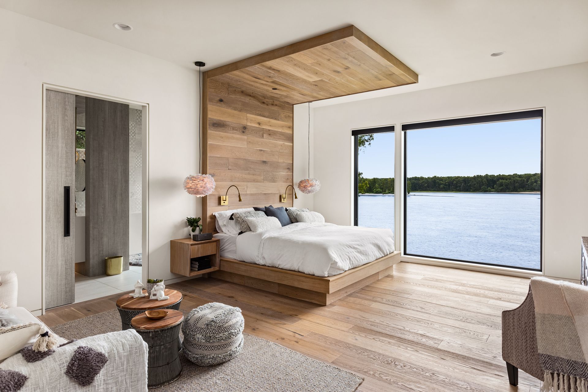 A bedroom with a large bed and a view of a lake.
