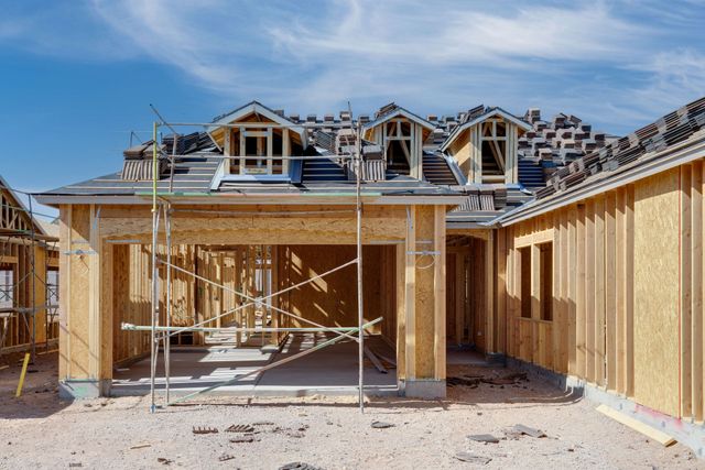 A house is being built in the desert with scaffolding around it.