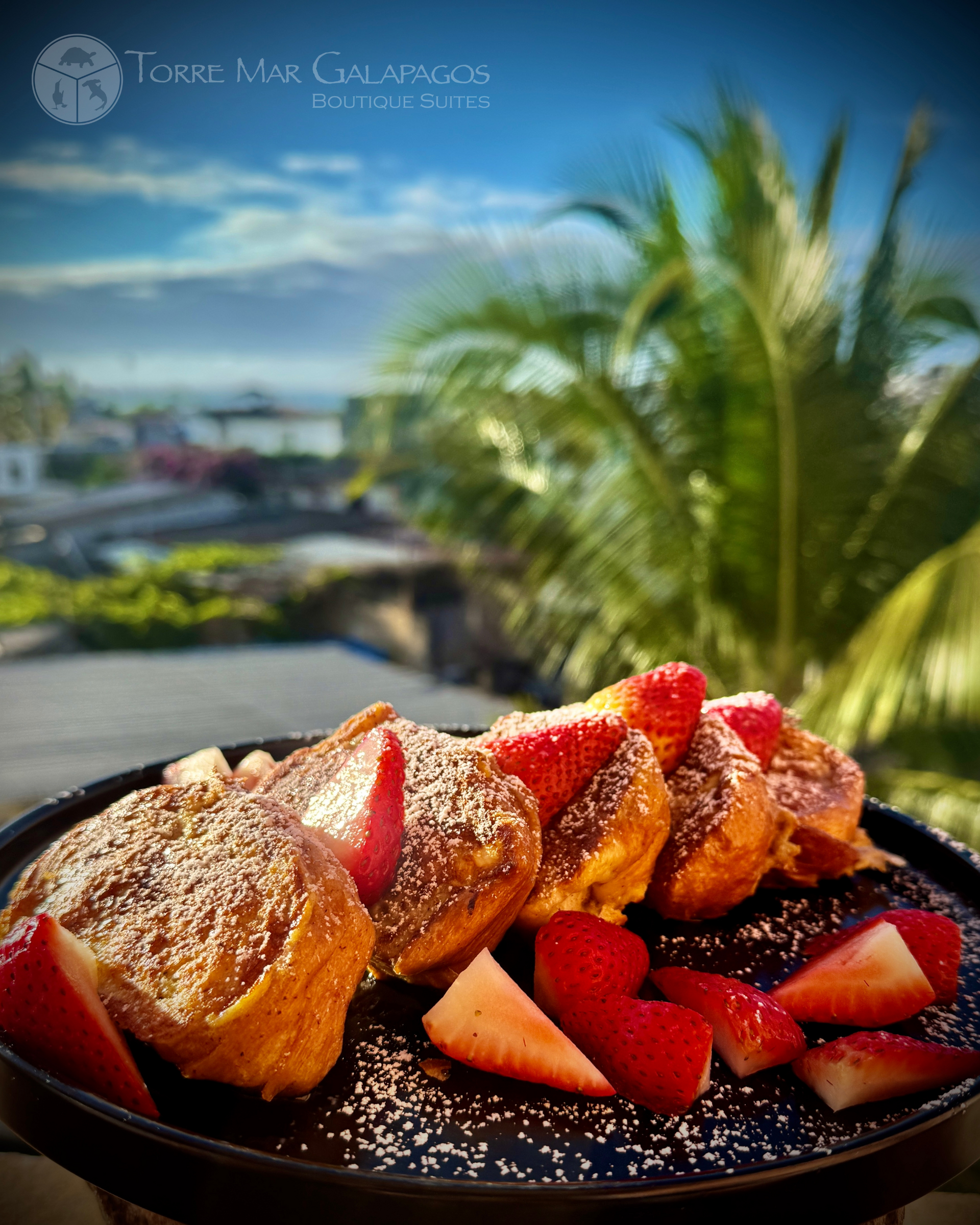 French toast with strawberries and powdered sugar on a plate being served at a Galapagos Hotel.