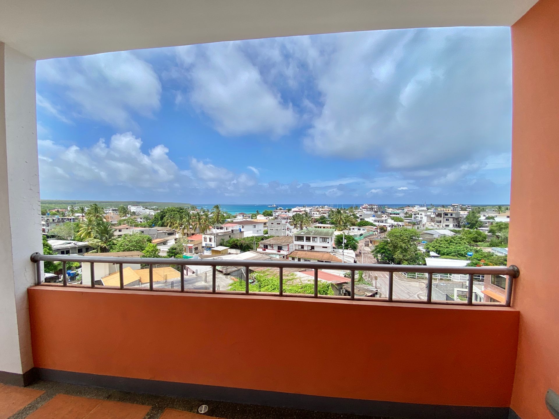 A Galapagos hotel Balcony view of the coastal town Puerto Ayora under a partly cloudy blue sky