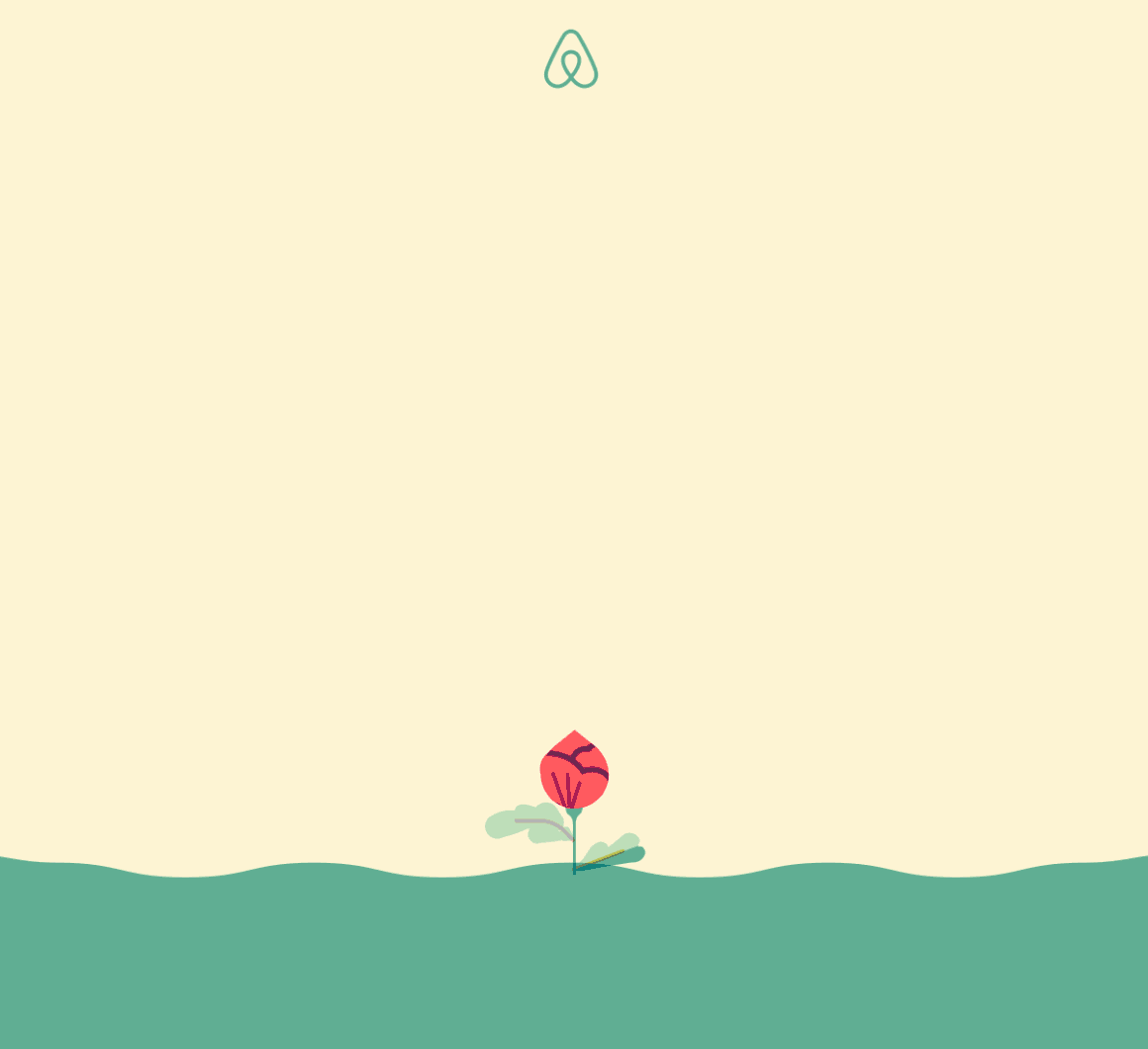 A small red flower is growing out of the ground.