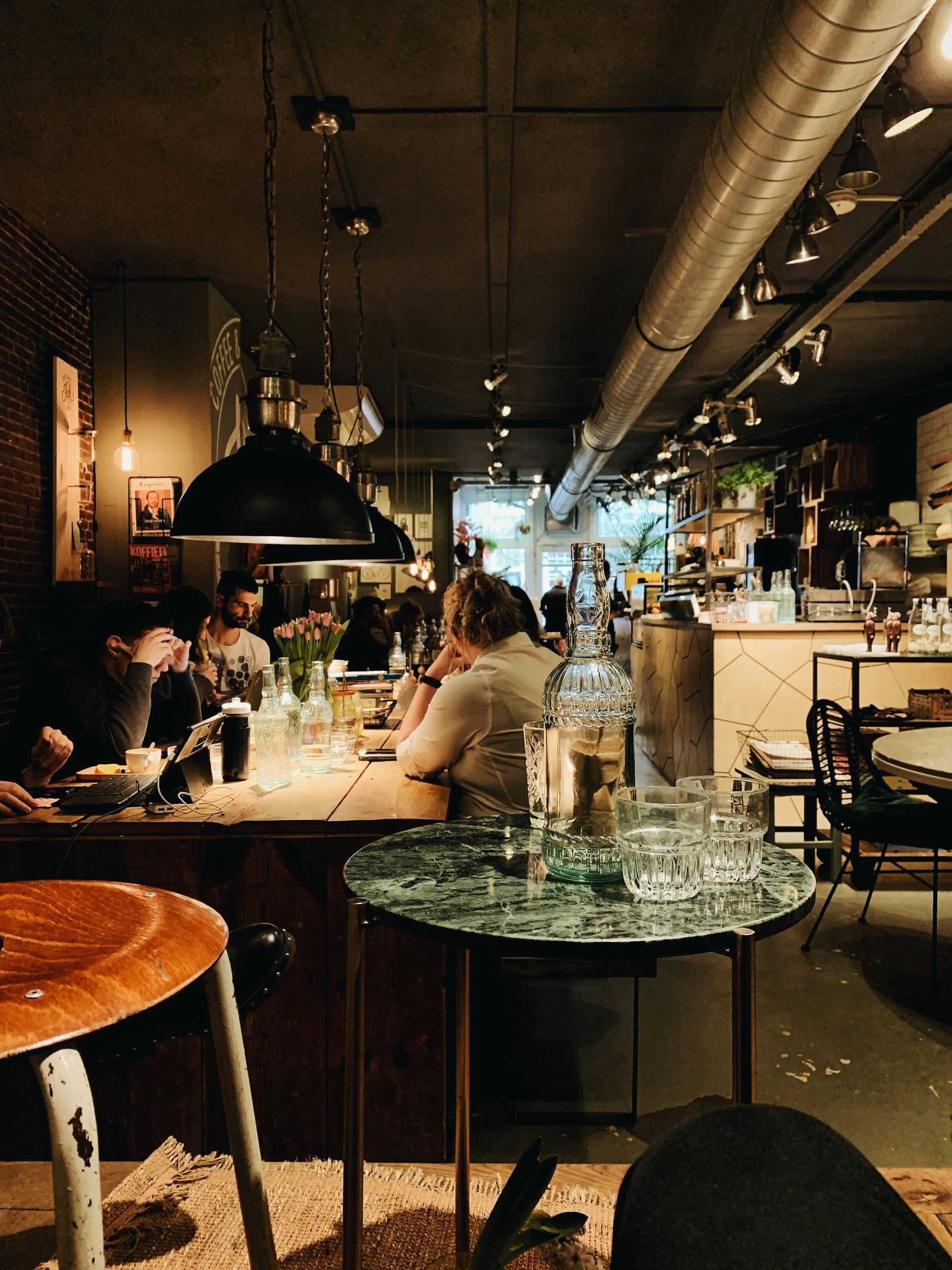A group of people are sitting at tables in a restaurant.