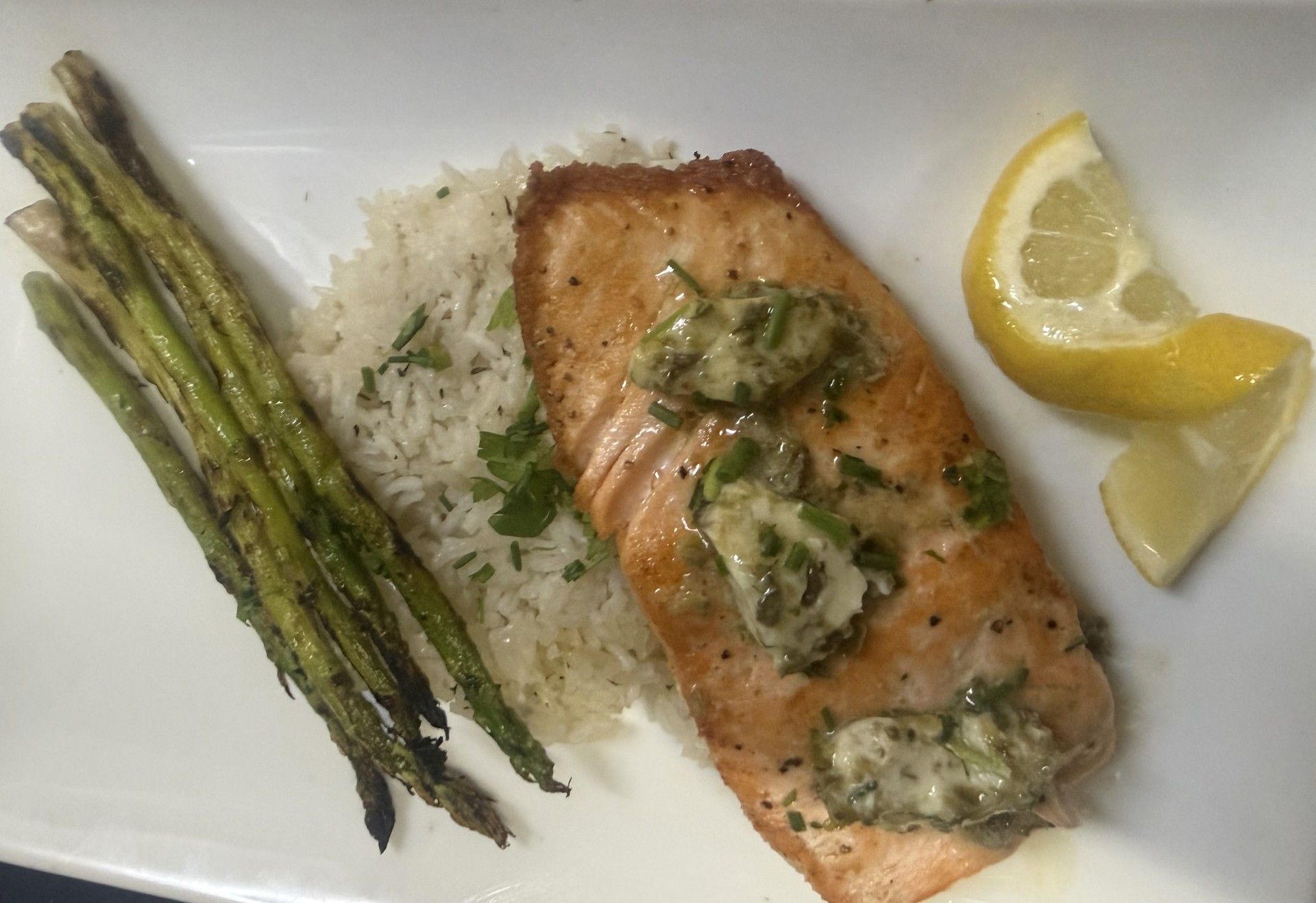 A plate of food with rice and asparagus on a table.
