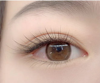 Close-up of a brown eye with long eyelashes and soft pink eye makeup
