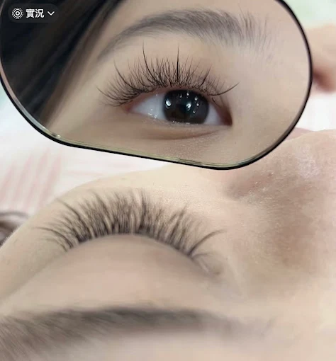 Close-up of an eye with long eyelashes and a zoomed inset showing the eye opening and makeup detail