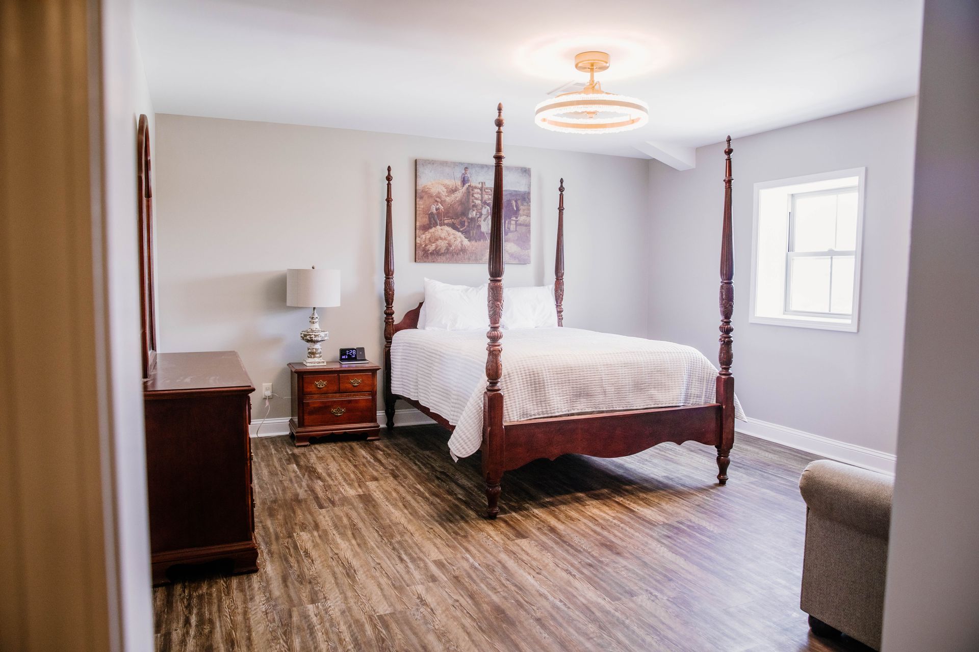 Modern hotel room with a neatly made bed, wood headboard, and map artwork above the bed