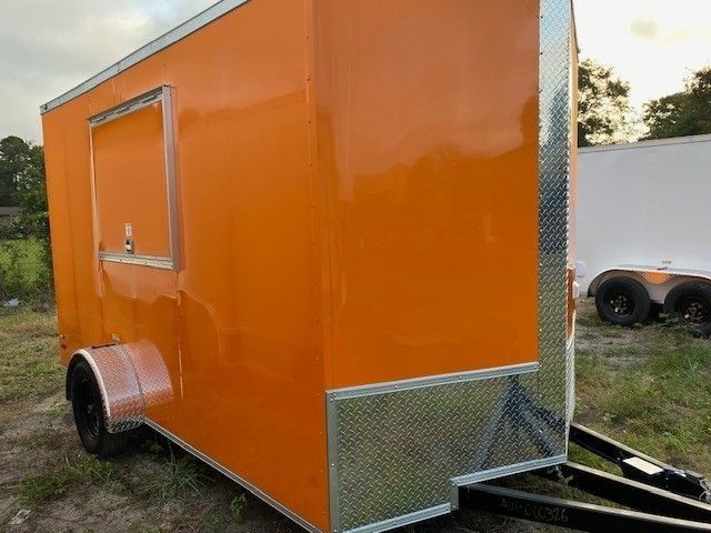 Orange food trailer with a serving window and diamond plate trim.