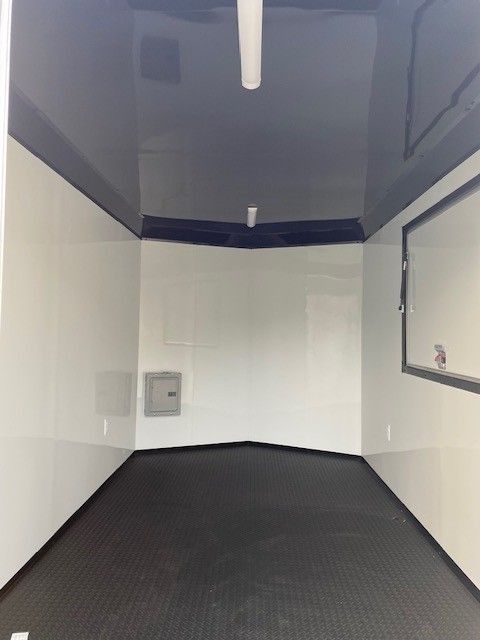Empty black and white trailer interior. White walls, black ceiling and floor.