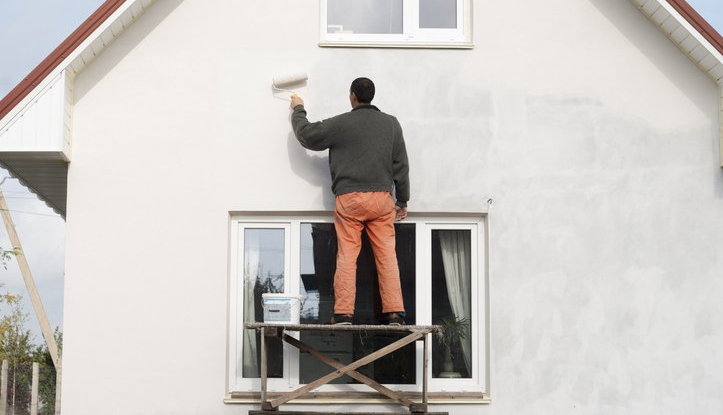 Worker is painting a wall