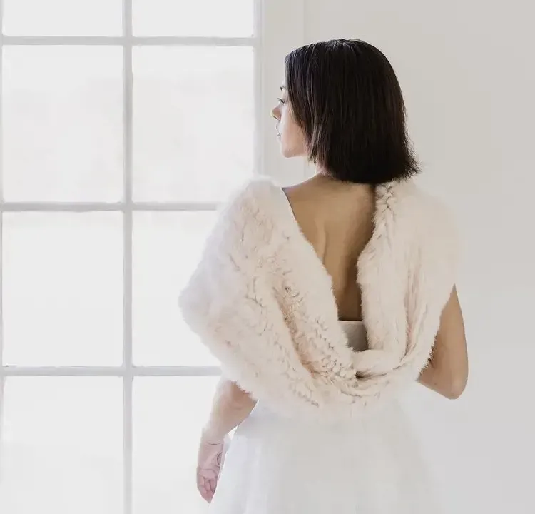The back of a woman wearing a white fur shawl
