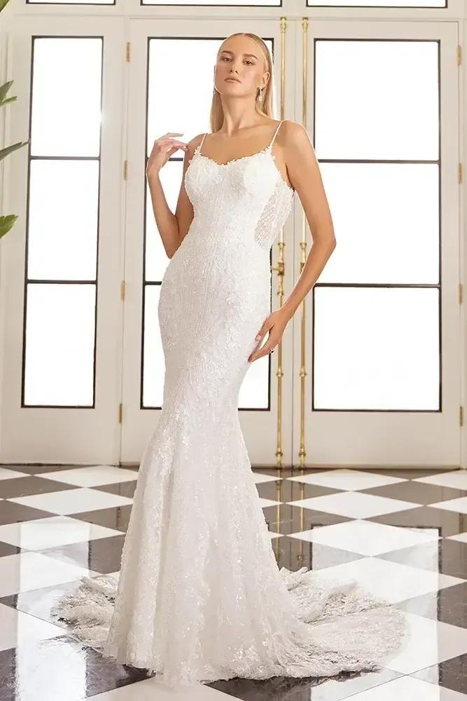 A woman in a white wedding dress is standing in front of a checkered floor.