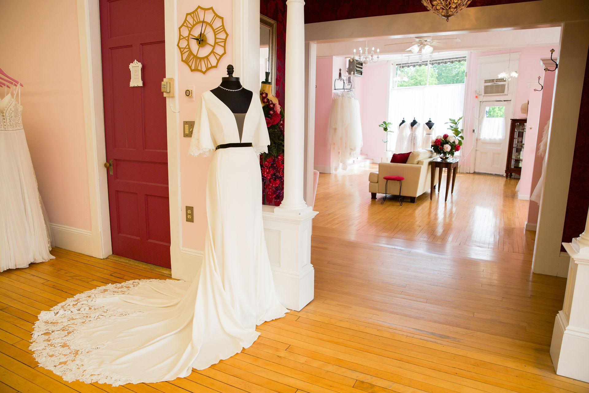 A wedding dress is sitting on a mannequin in a room.