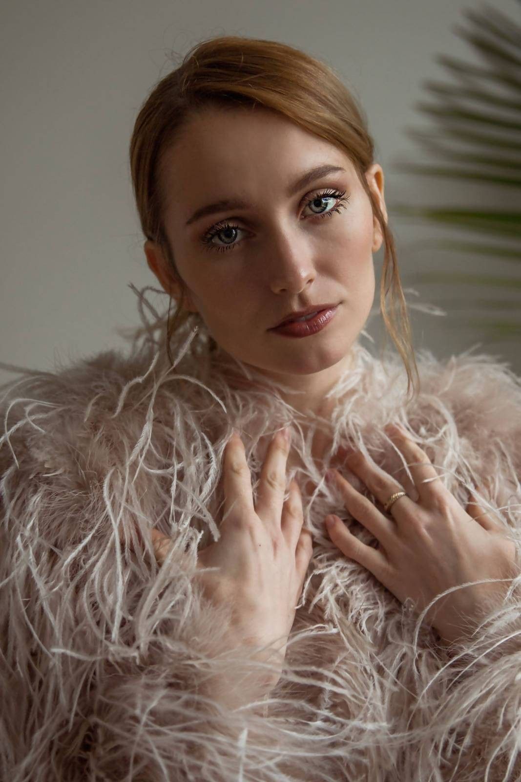 A woman is wearing a fur coat with feathers on it.