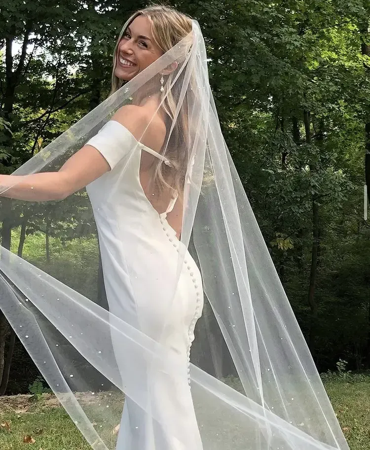 A woman in a white dress with a veil on her head