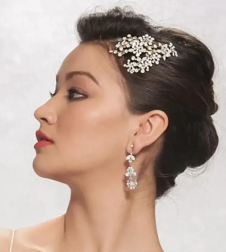 A woman wearing earrings and a comb in her hair