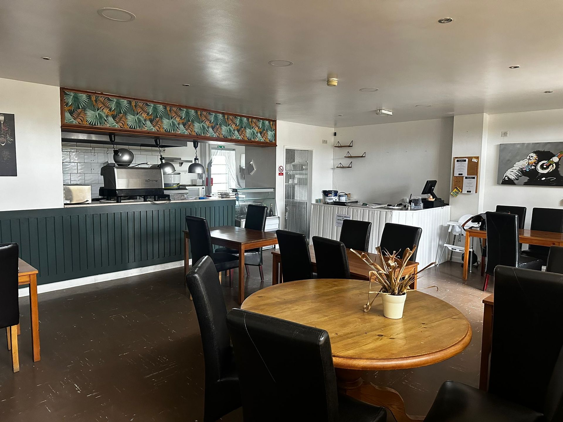 A restaurant with tables and chairs and a counter.