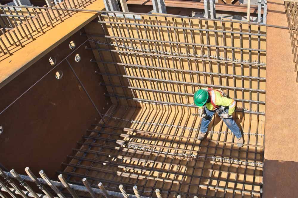 Worker Inside a Construction Site With Steel Rebar Framework — Easy Mix Concrete In Gosford, NSW
