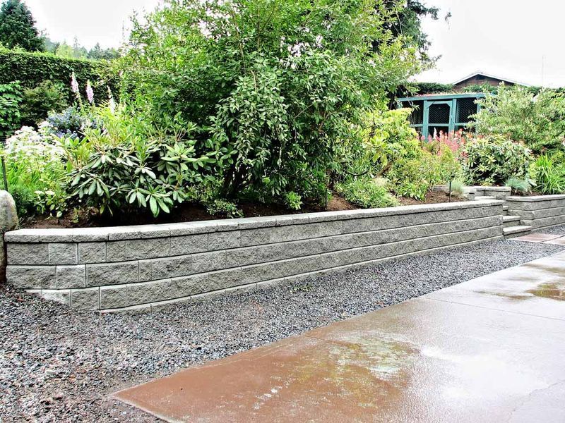 Stone Retaining Wall in a Garden With Plants and Gravel — Easy Mix Concrete In Erina, NSW