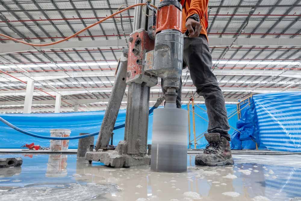 Construction Worker Using a Core Drill to Bore a Hole in Concrete — Easy Mix Concrete In Woy Woy, NSW