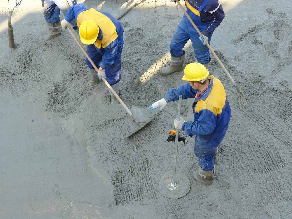 Construction Workers in Blue Coveralls and Yellow Hard Hats — Easy Mix Concrete In Berkeley Vale, NSW