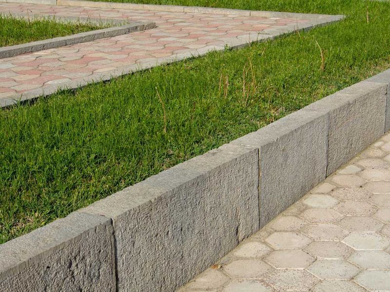 Stone Curb Separates Green Grass and Patterned Sidewalk — Easy Mix Concrete In Charmhaven, NSW