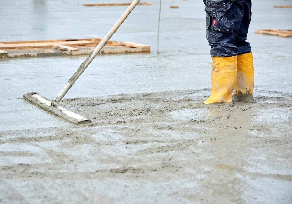 Person in Yellow Boots Floats Wet Concrete — Easy Mix Concrete In Gosford, NSW