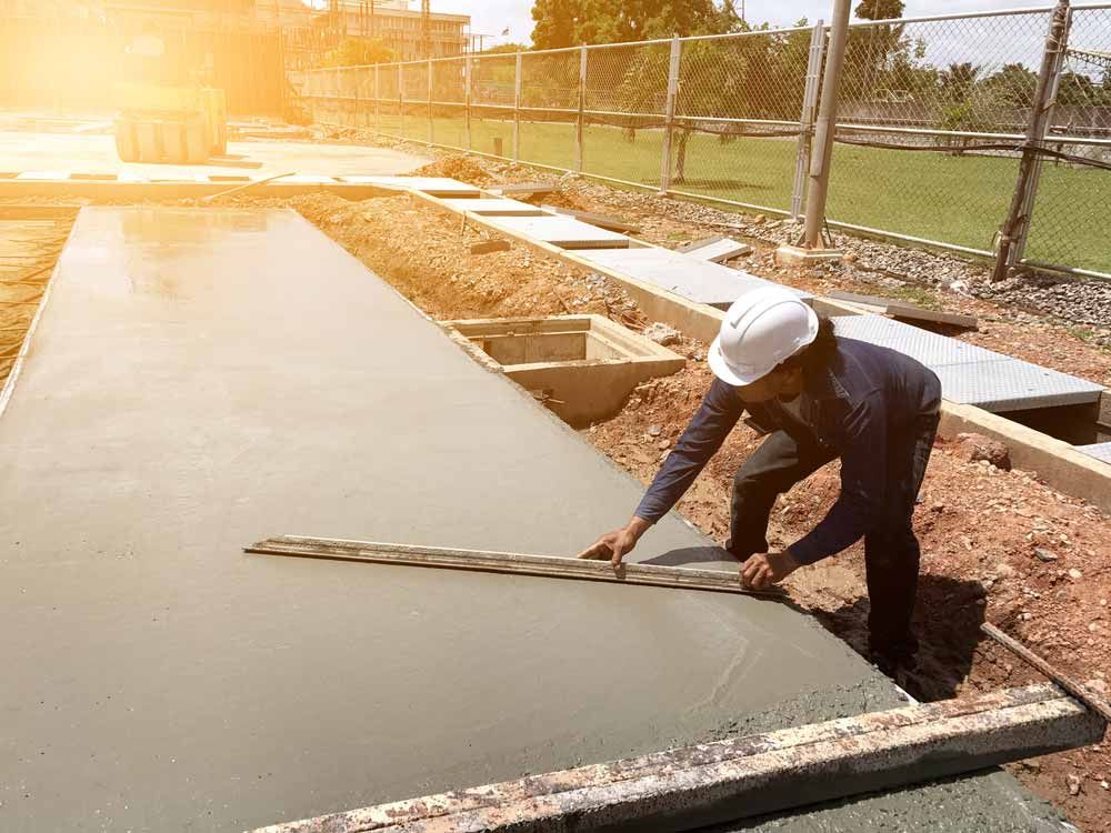 Construction Worker Leveling Wet Concrete — Easy Mix Concrete In Erina, NSW
