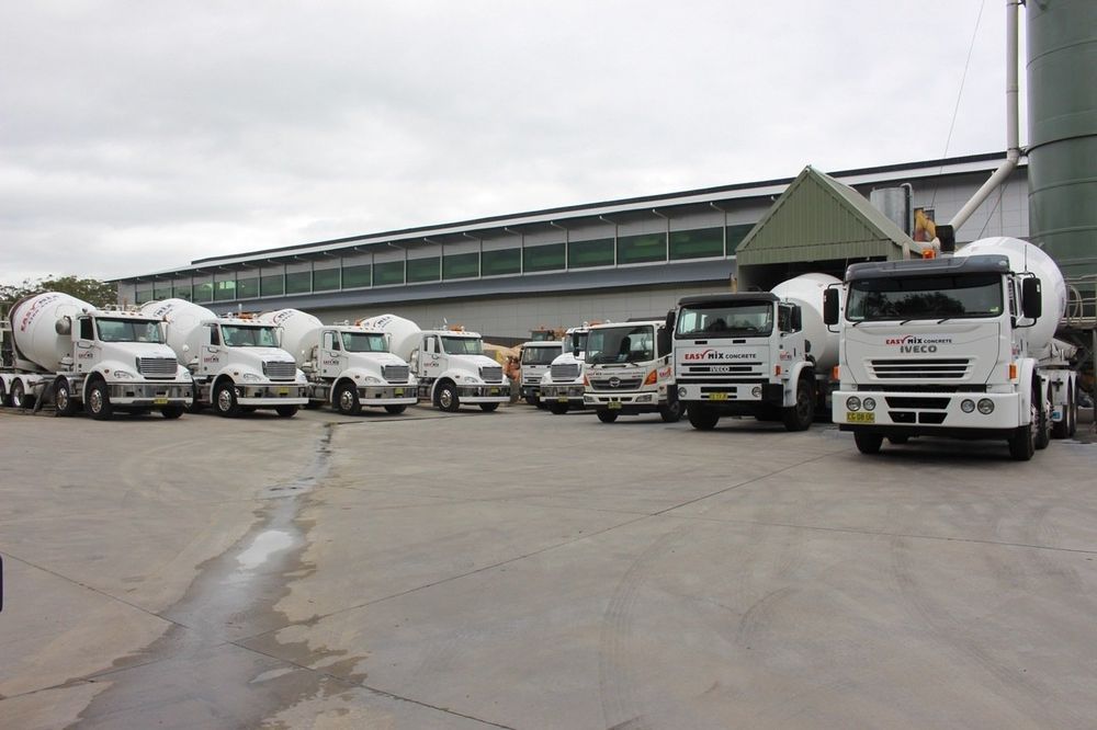 Cement Trucks Lined Up in Front of a Building — Easy Mix Concrete in Berkeley Vale, NSW