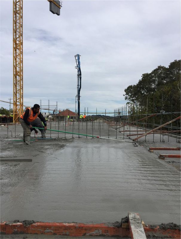 Construction Worker Leveling Wet Concrete — Easy Mix Concrete in Berkeley Vale, NSW