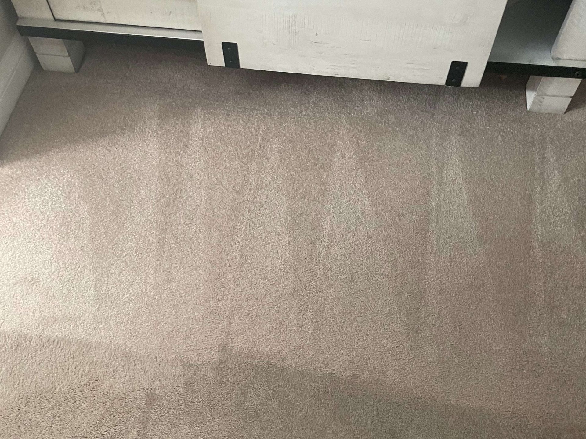 Carpeted floor with a white cabinet or appliance at the top edge.