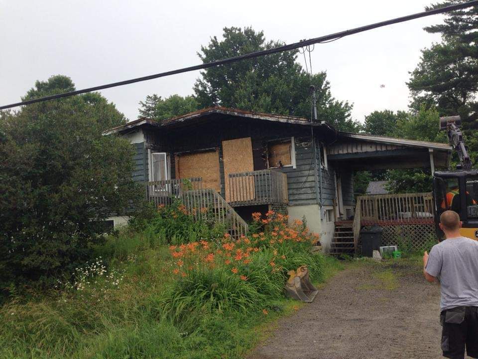 Un homme se tient devant une maison fermée à clé