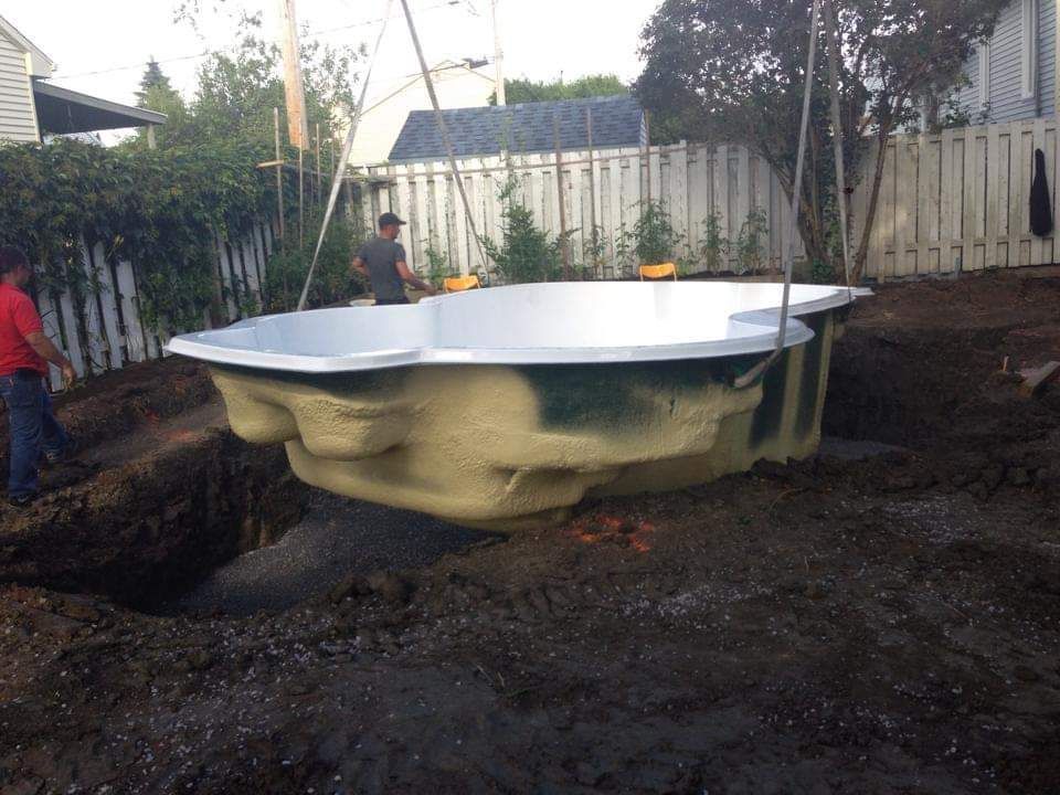 Une grande piscine est en cours de construction dans une cour.