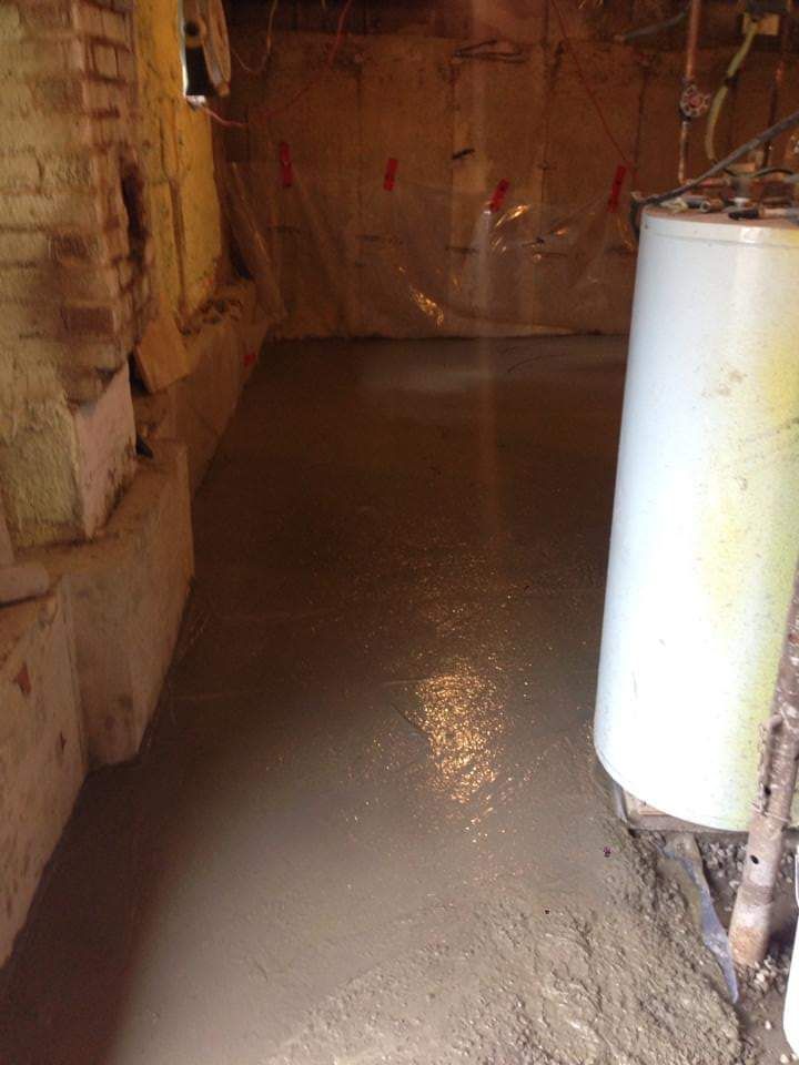 Un plancher de béton dans un sous-sol avec chauffe-eau.