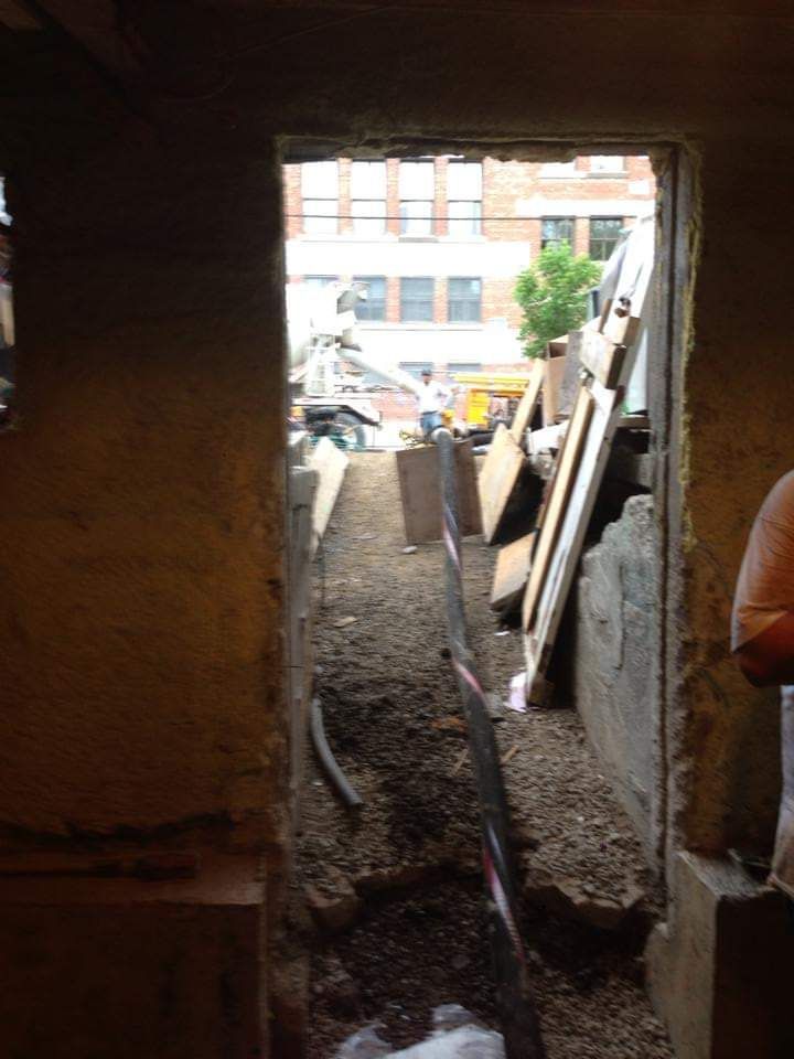Une personne se tient devant une porte donnant sur un chantier de construction.