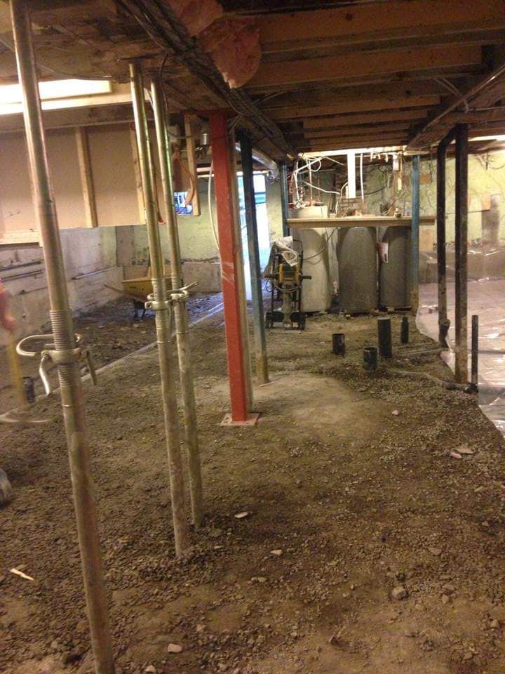 Un sous-sol en construction avec des échafaudages et une brouette.