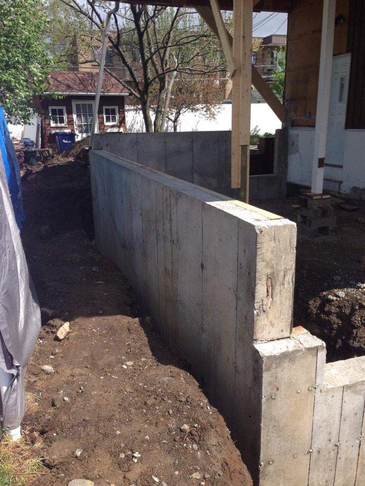 Un mur de béton est en cours de construction devant une maison