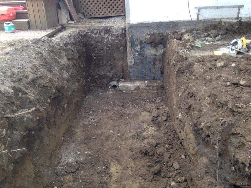 Un gros tas de terre est creusé devant une maison.