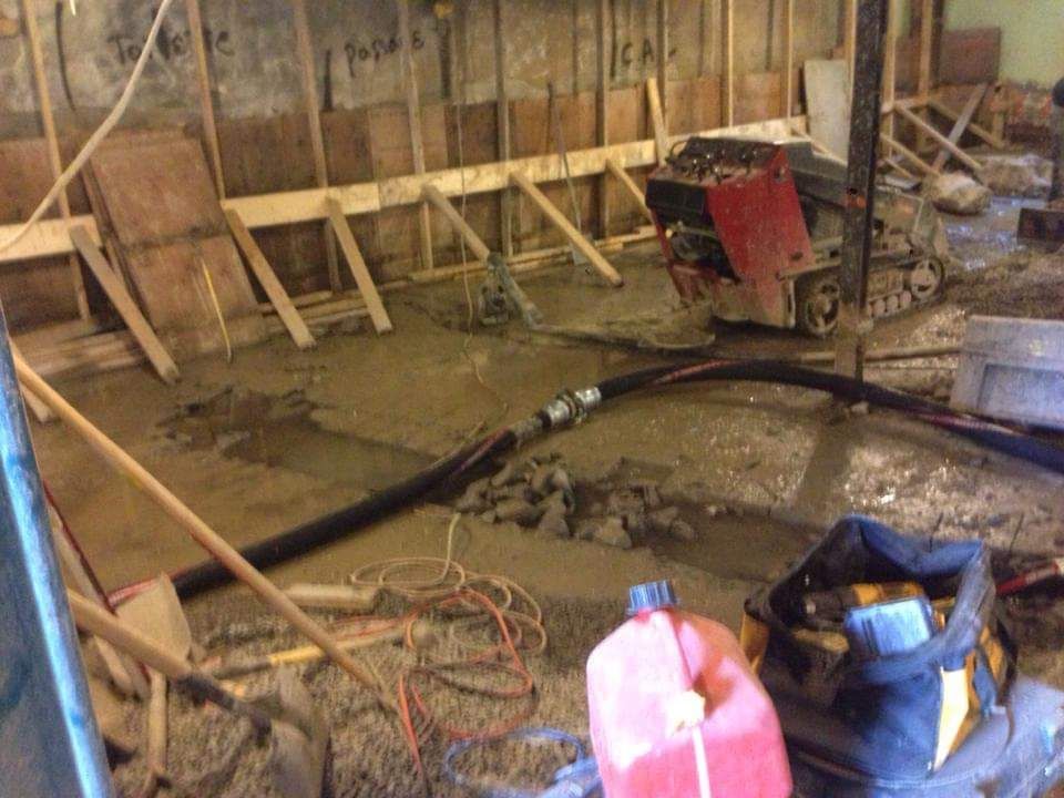 Un aspirateur est posé sur le sol d'un immeuble en construction.