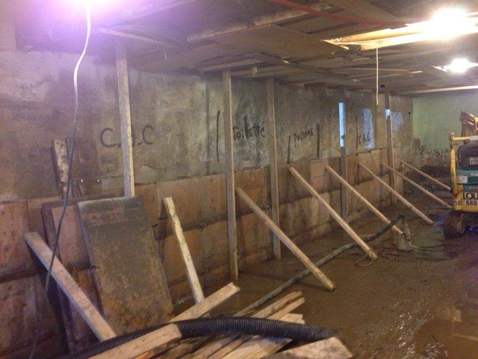 Un mur de béton est en cours de construction dans un sous-sol.