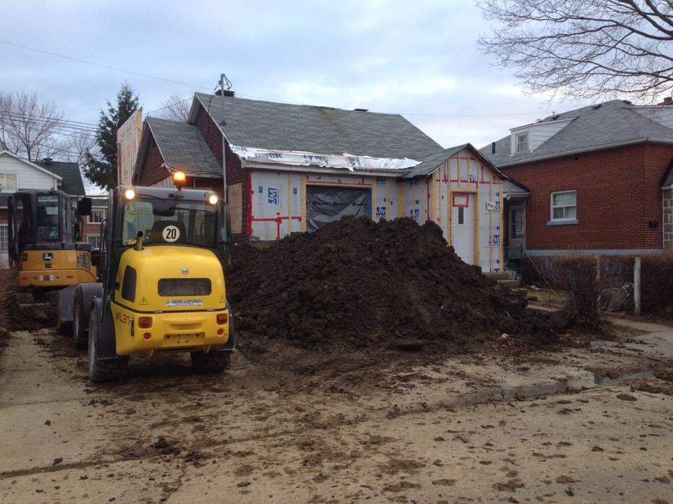 Un gros tas de terre se trouve devant une maison en construction