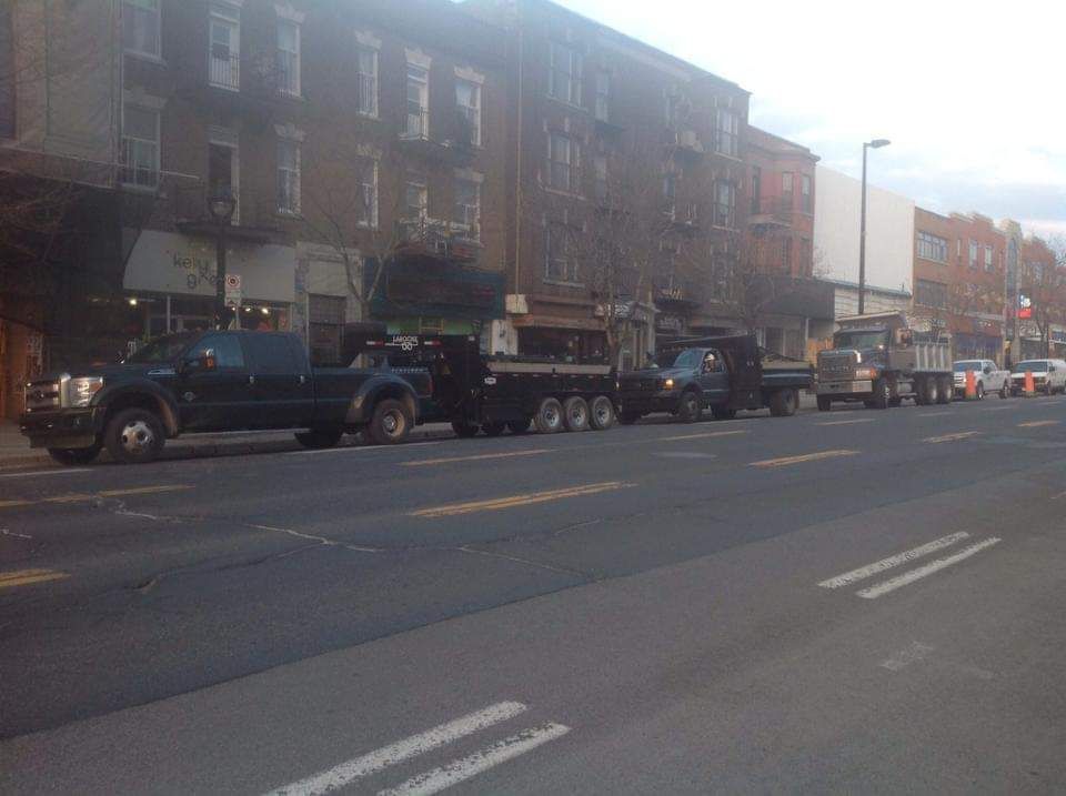 Une rangée de camions est garée au bord d'une rue de la ville.
