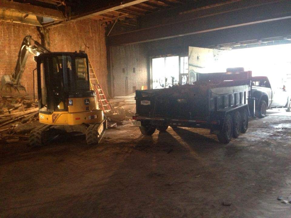 Un camion-benne est garé dans un garage à côté d'une excavatrice.