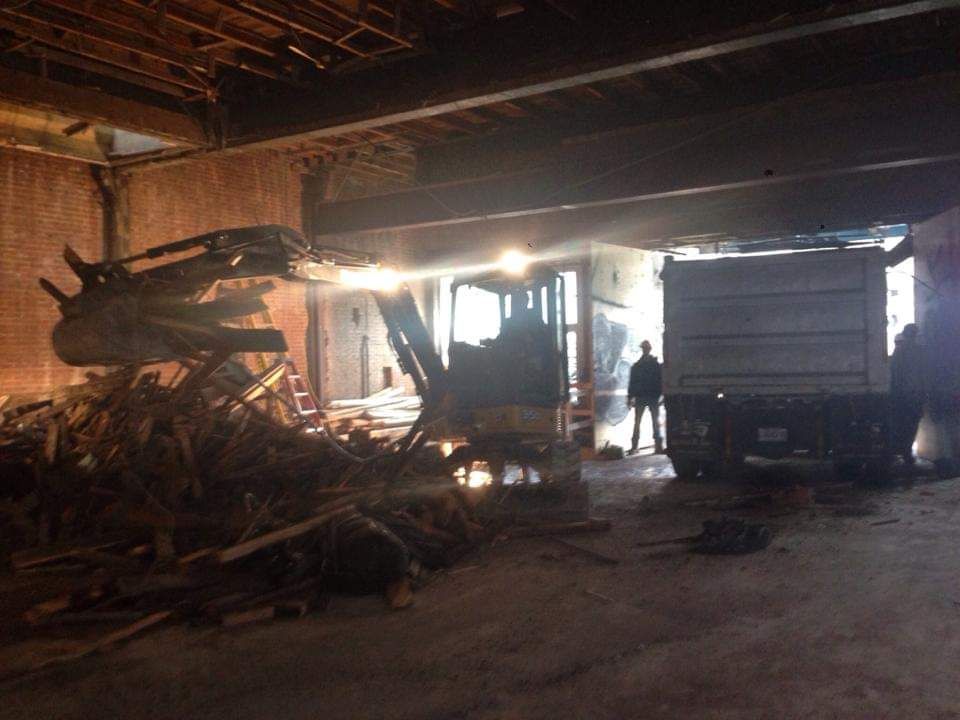 Un gros tas de bois repose dans une pièce sombre à côté d'un camion.