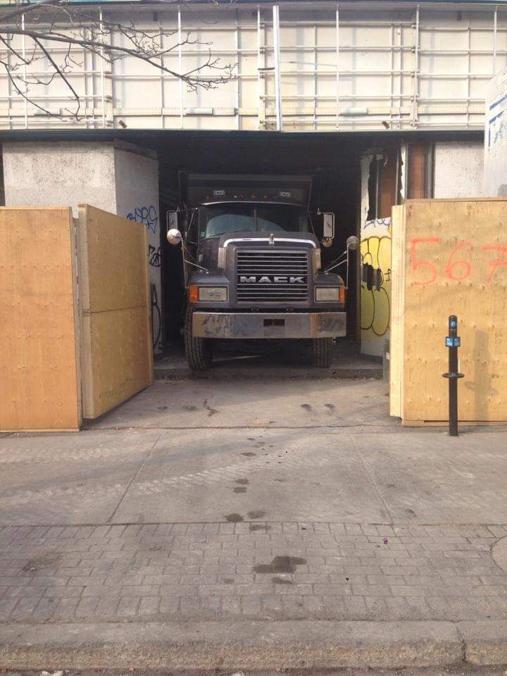 Un camion mack est garé devant un immeuble
