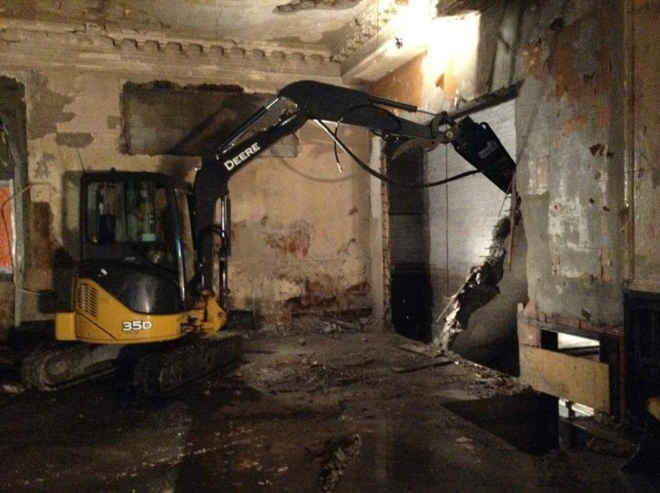 Une excavatrice Deere est utilisée pour démolir un bâtiment